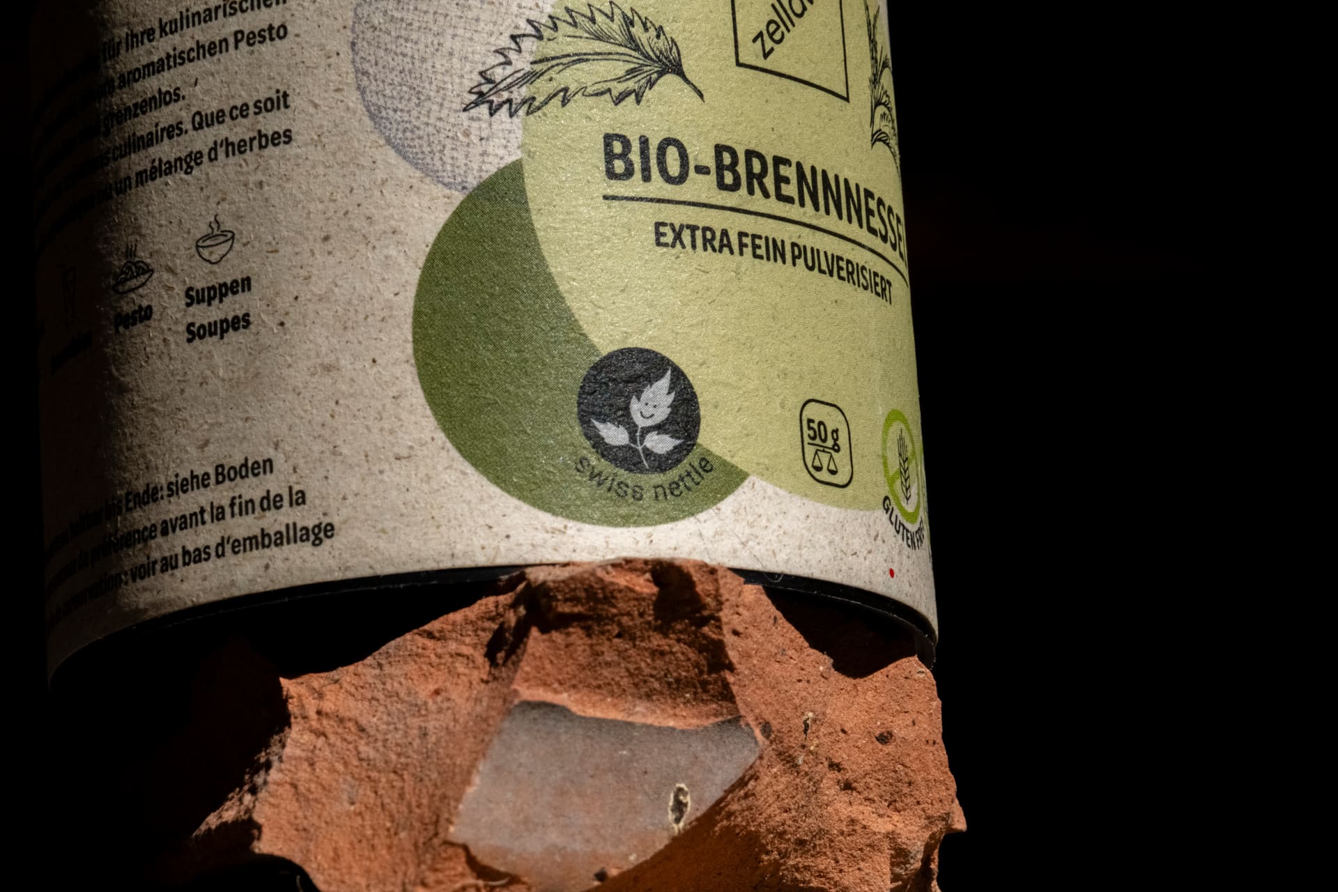 Brennnesselpulver in Bewegung – Staub- und Partikelwolke vor dunkelgrünem Hintergrund